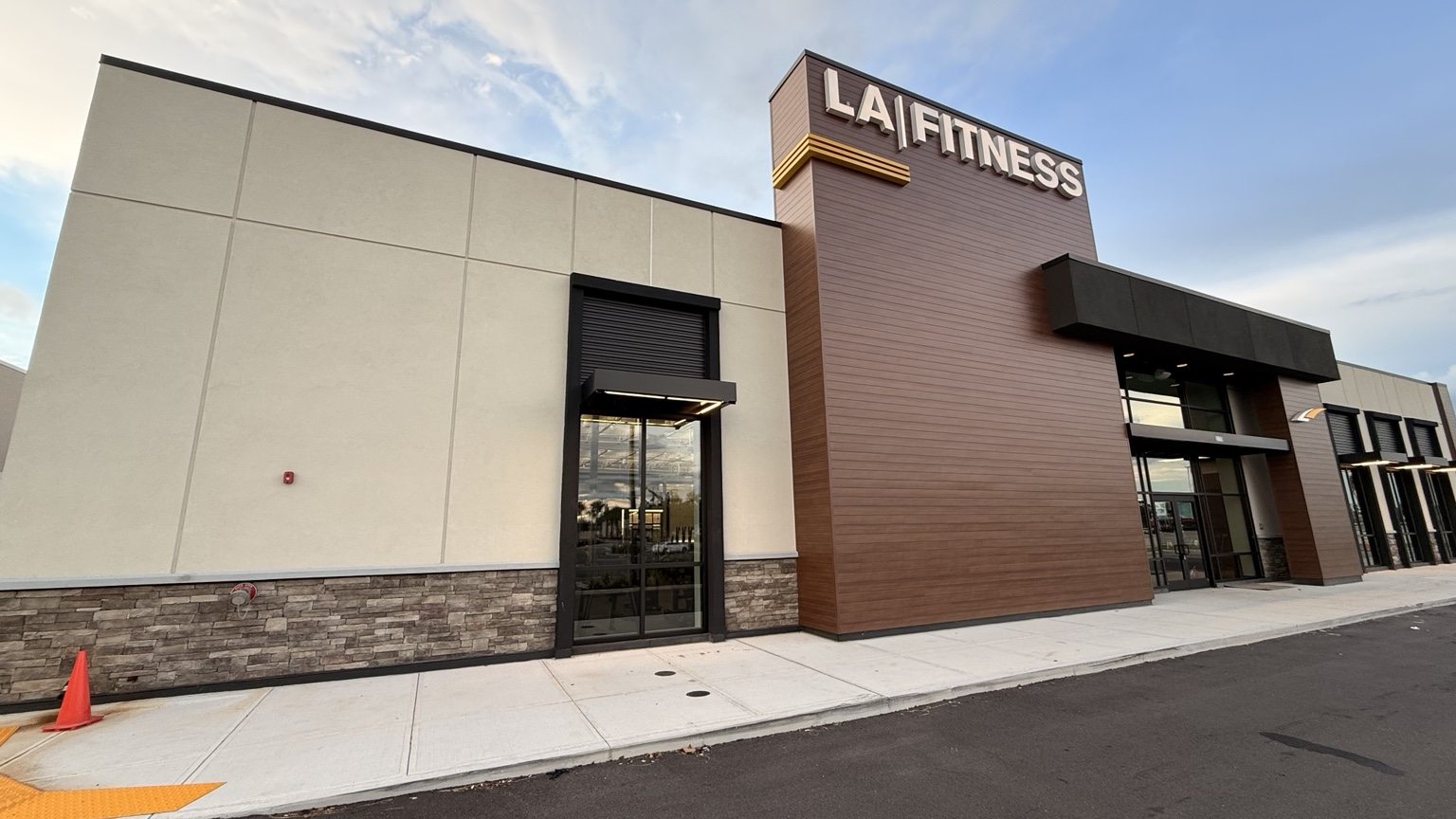 Completed LA Fitness exterior with finished cladding, sign, and entry